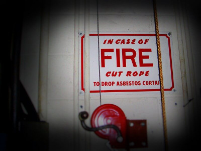 sign describing how to use an asbestos theater curtain