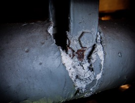 Section of exposed asbestos pipe insulation Section of exposed asbestos pipe insulation