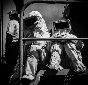 Black and white photo of Navy firefighters in asbestos suits