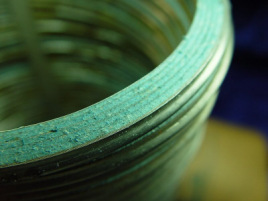 Close-up surface-view of fibrous asbestos insulation material in a vintage Flexitallic spiral-wound gasket