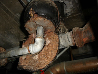 Example of vintage, thick cork pipe insulation with non-asbestos bituminous tar-like outer coating and asbestos-containing seam compound.