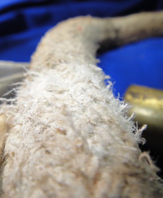 Closer view of a high-percentage chrysotile asbestos joint runner, showing frayed fibrous nature of the braided textile vintage plumbing tool.