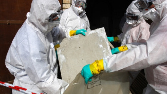 Asbestos removal workers in protective clothing
