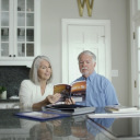 Couple reading asbestos cancer book in kitchen