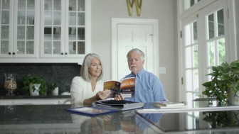 Couple reading asbestos cancer book in kitchen