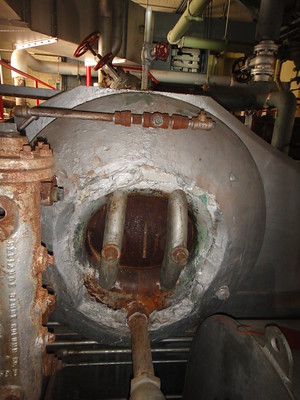 Example of an industrial-type boiler drum and access port. Damage to the asbestos insulation is present around the inner edges of the material