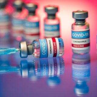 Vials of COVID-19 vaccine and needle