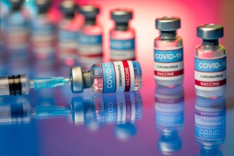 Vials of COVID-19 vaccine and needle