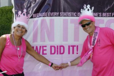 Couple holding hands in front of cancer awareness sign