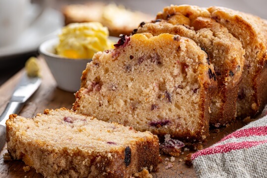 Cranberry orange bread sliced on a board