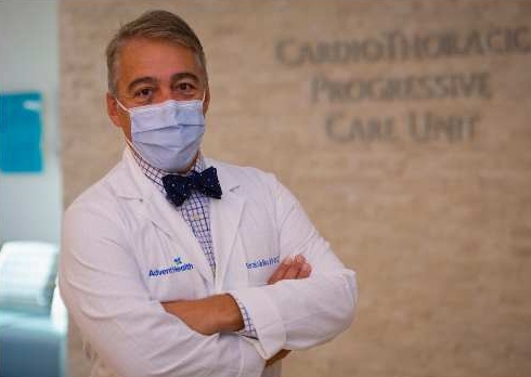 Dr. DaSilva with mask, hands folded, in AdventHealth white coat.