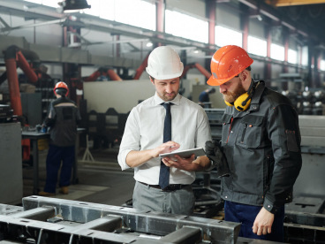 Two men in hard hats in manufacturing plant