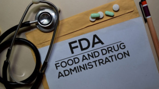 Stethoscope and a folder of FDA documents with prescription pills