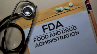 Stethoscope and a folder of FDA documents with prescription pills