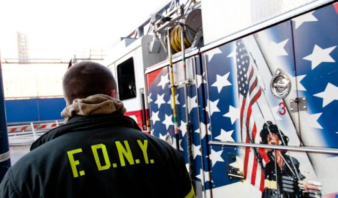 FDNY firefighter looking at 9/11 memorial on fire truck