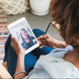 Woman and teen visiting over FaceTime on tablet