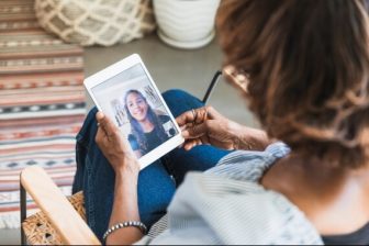 Woman and teen visiting over FaceTime on tablet