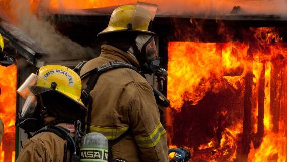 Firefighters fighting flames and toxic smoke