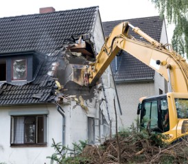 Tractor tearing down a house