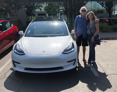 Jim and Kathy Huff with their white Tesla