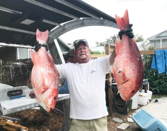 Kevin Sinyard holding two red snapper fish