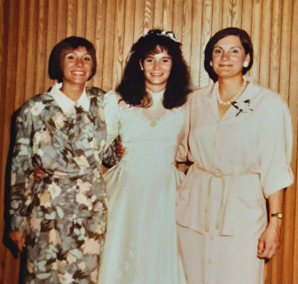 two women pose for a picture with a bride