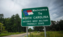 A sign on a two-lane country road welcomes residents and visitors to North Carolina.