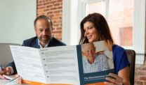 Jose Ortiz and Missy Miller with a brochure from The Mesothelioma Center