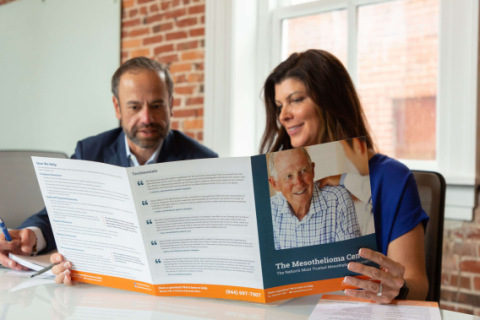 Jose Ortiz and Missy Miller with a brochure from The Mesothelioma Center