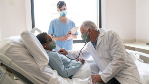 Patient in hospital bed with doctor and nurse