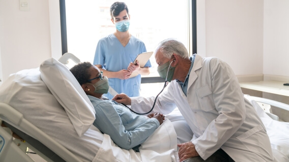 Patient in hospital bed with doctor and nurse