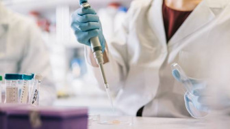 Close up of scientist hands, taking samples with pipette