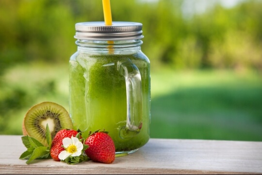 Green smoothie with strawberries and kiwi