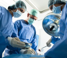 Surgeons in scrubs operating on a patient