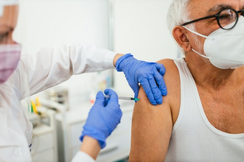 Doctor giving vaccine to patient in doctor's office