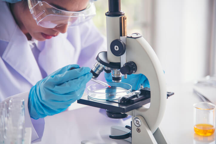Woman scientist in lab look at science microscope medical test and research biology chemistry. Females technician laboratory analyzing scientific pharmacy genetic research.