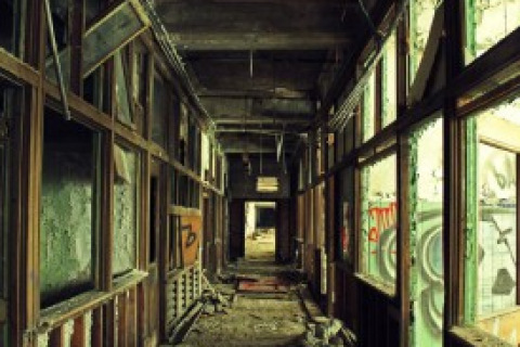 Abandoned hallway with broken glass and exposed building materials