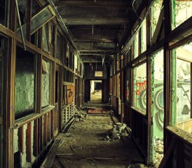 Abandoned hallway with broken glass and exposed building materials