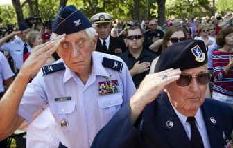 Two U.S. Air Force veterans saluting in a crowd