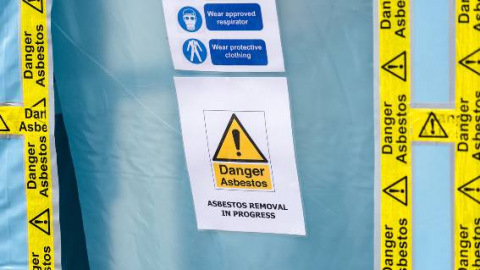 Danger Asbestos tape and sign on blue sheet