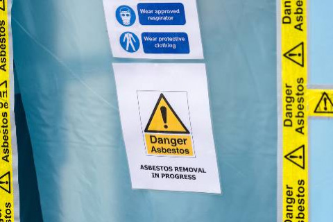 Danger Asbestos tape and sign on blue sheet