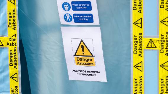 Danger Asbestos tape and sign on blue sheet