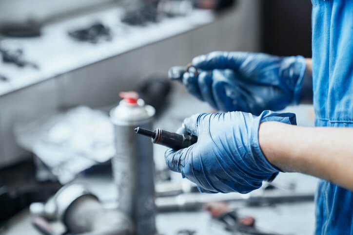 Auto mechanic holding a spark plug