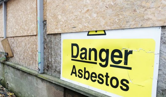 Asbestos warning on boarded up building