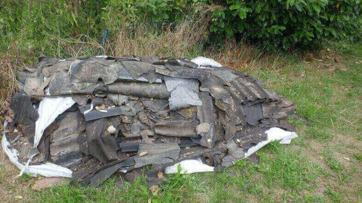 Shingles and waste materials from a home remodel dumped in a ditch