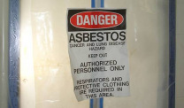 Asbestos danger sign on plastic-covered door