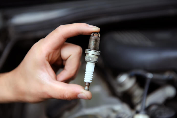 Auto mechanic handling a spark plug