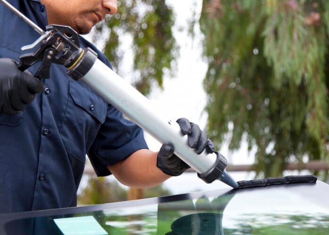 Auto mechanic repairing a glass window