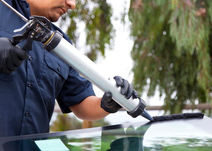 Auto mechanic repairing a glass window