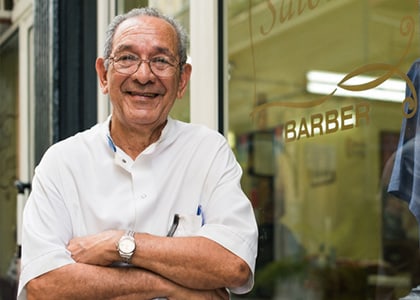 Elderly barber outside barber shop